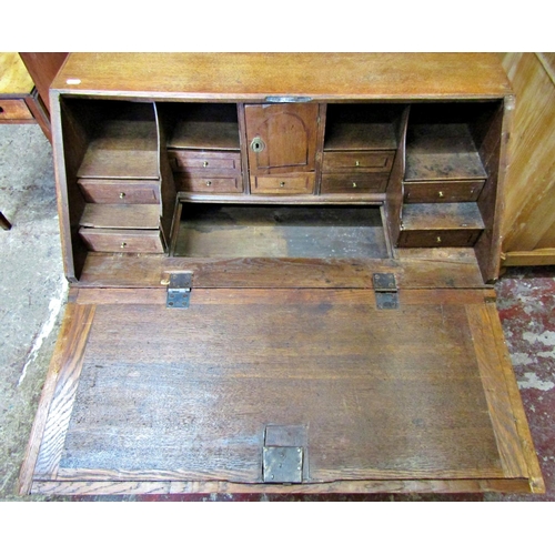 2514 - An 18th century oak country made bureau of two long and two short drawers, the fall flap revealing a... 