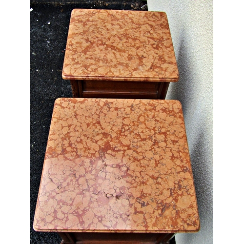 2529 - A pair of carved oak bedside/lamp tables each with polished marble tops over a frieze drawer and cup... 