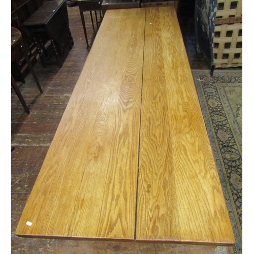 2593 - An oak refectory table, the heavy plank top raised on a simple stretcher base united by a central ra... 