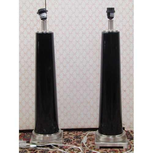 2669 - A pair of contemporary table lamps, the polished chrome bases supporting a cylindrical tapering blac... 