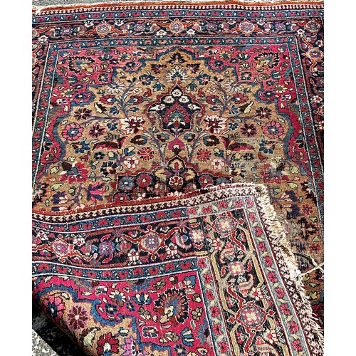 1647 - An old Persian carpet with a central floral medallion on a field of flowers, 104cm x 74cm approx.