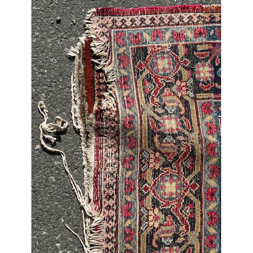 1647 - An old Persian carpet with a central floral medallion on a field of flowers, 104cm x 74cm approx.