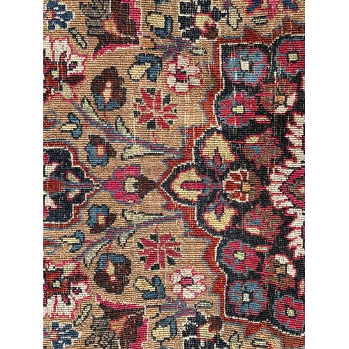 1647 - An old Persian carpet with a central floral medallion on a field of flowers, 104cm x 74cm approx.