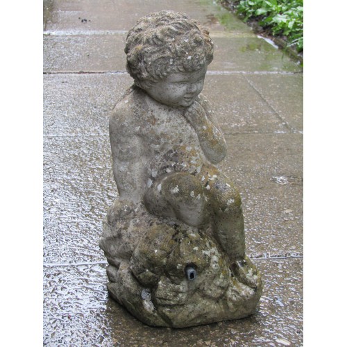 2005 - A small weathered cast composition stone water feature in the form of a seated crossed legged cherub... 