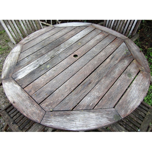 2 - A weathered teak circular folding garden table with slatted top, 125 cm diameter together with a set... 