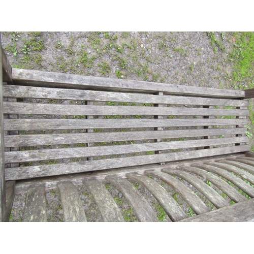 12 - A weathered teak garden bench with slatted seat and back with curved splats (af) 148 cm wide