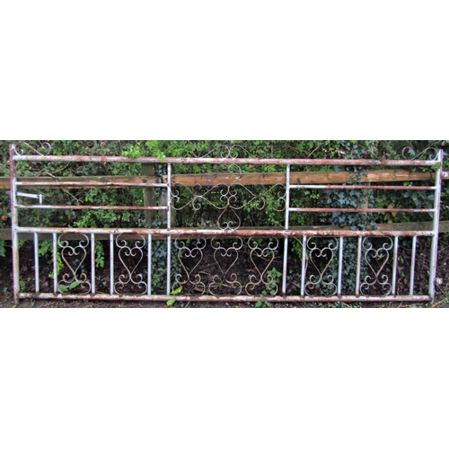 53 - A large weathered tubular steel framed driveway/field gate with open scrollwork panels and simple la... 