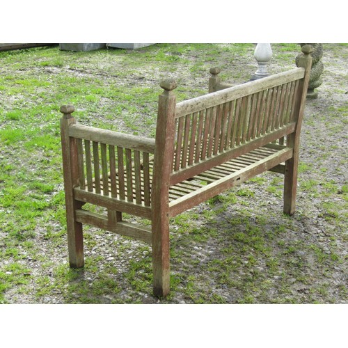 39 - A vintage Arts & Crafts style weathered teak two seat garden bench with slender slatted seat and bac... 