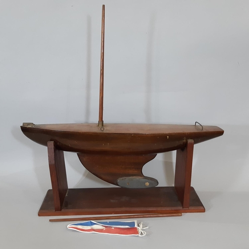 1278 - Traditional timber pond yacht with weighted keel and wooden stand. Length of hull 62cm (no sails)