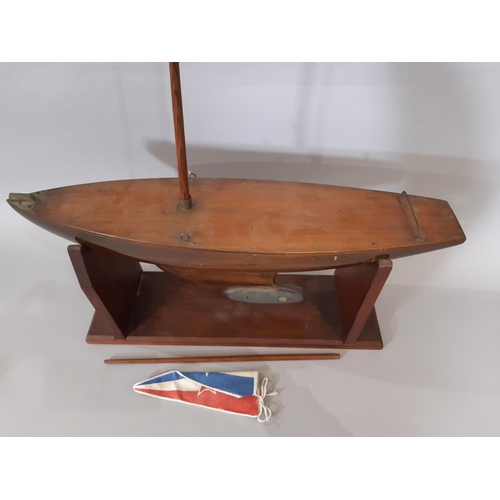 1278 - Traditional timber pond yacht with weighted keel and wooden stand. Length of hull 62cm (no sails)