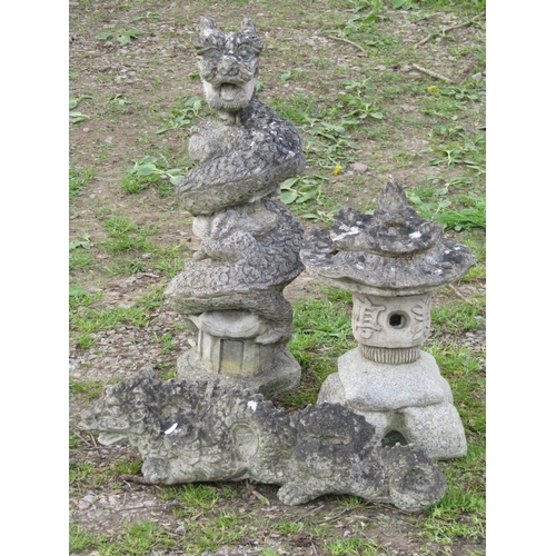 107 - A collection of weathered mainly cast composition stone Far Eastern garden ornaments comprising a pa... 