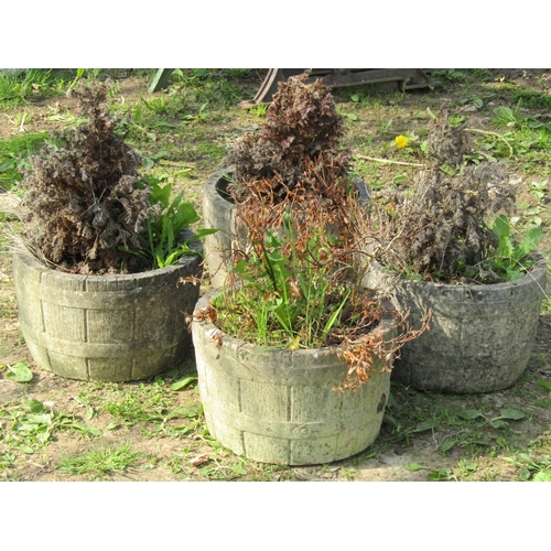 109 - A set of four weathered cast composition stone garden planters in the form of coopered half barrels,... 