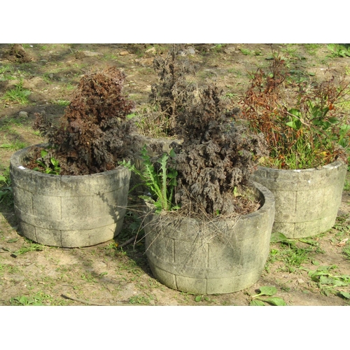 109 - A set of four weathered cast composition stone garden planters in the form of coopered half barrels,... 