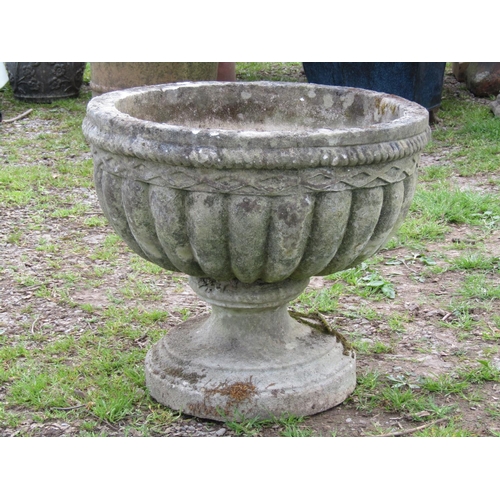 113 - A weathered cast composition stone garden urn, the squat circular lobed bowl with rope twist band ra... 