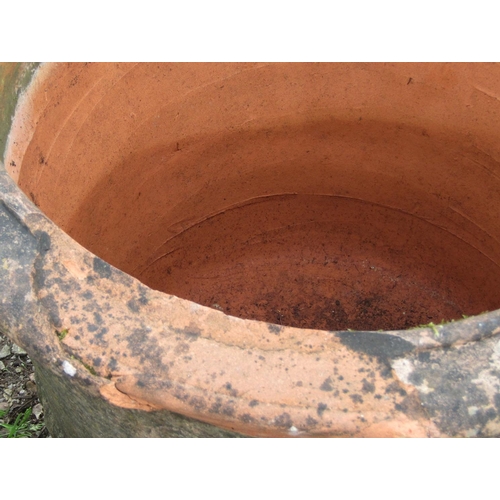 124 - A pair of weathered terracotta planters of circular tapered form with moulded rims, ribbed and incis... 