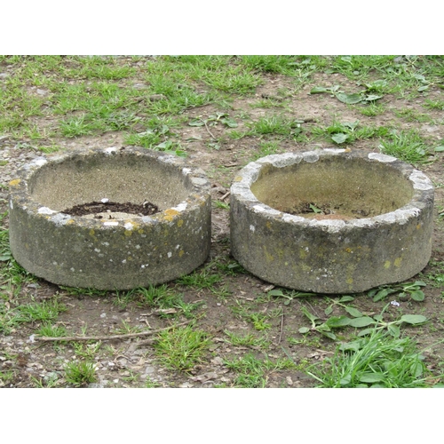 134 - A pair of nicely weathered shallow circular composition stone planters 38 cm in diameter x 14 cm hig... 