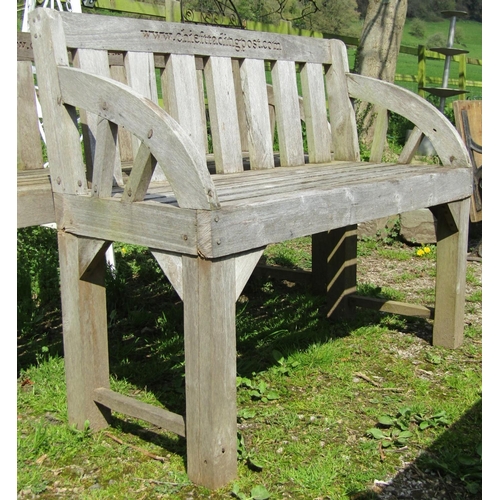 140 - A weathered hardwood two seat garden bench with slatted seat, back and curved arms (stamped to back ... 