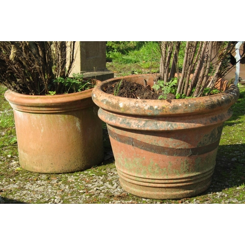 141 - Two weathered circular terracotta planters of varying size and design, the largest example approxima... 