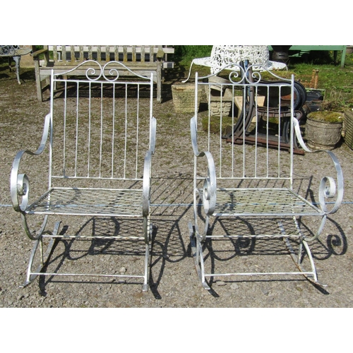 162 - A pair of decorative painted ironwork garden rocking chairs with open scrolled arms and lattice pane... 