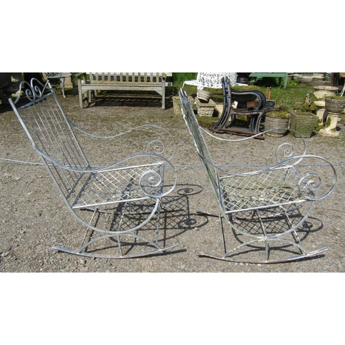 162 - A pair of decorative painted ironwork garden rocking chairs with open scrolled arms and lattice pane... 