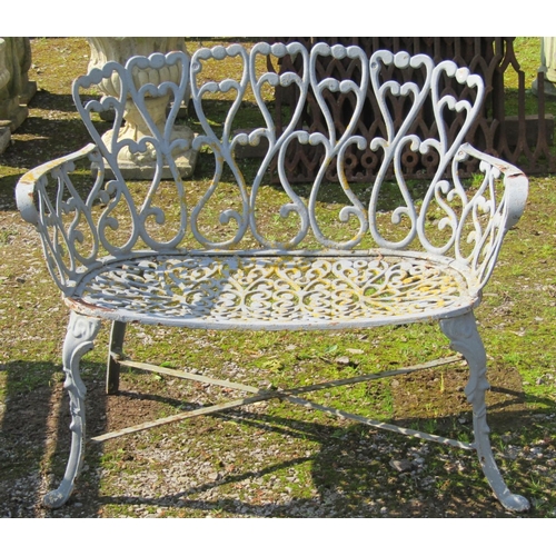 163 - A small painted and weathered heavy gauge cast iron garden bench with repeating open scroll pattern ... 