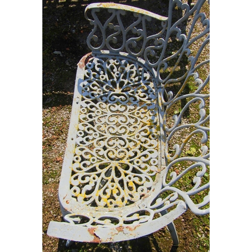 163 - A small painted and weathered heavy gauge cast iron garden bench with repeating open scroll pattern ... 