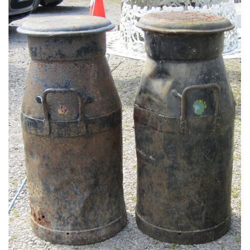 196 - A pair of weathered heavy gauge steel twin loop handled milk churns and caps, 74 cm high (af)