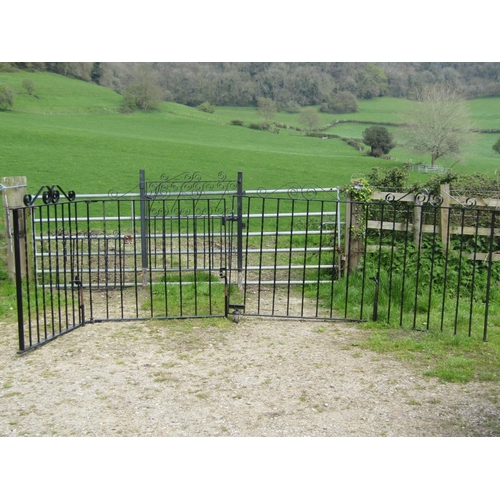 72 - A pair of unusual hinged folding iron work driveway entrance gates with twisted vertical bars and op... 