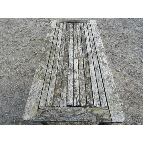 95 - A weathered Gloster teak two seat garden bench with slatted seat and back, 129cm wide, together with... 