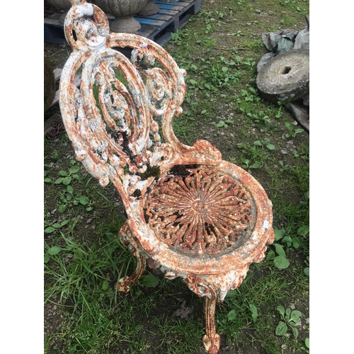 51 - A weathered heavy gauge Victorian cast iron garden chair with circular seat and decorative pierced a... 