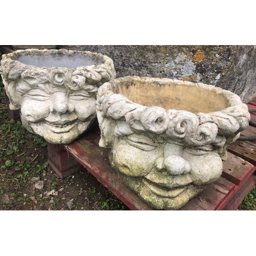 65 - A pair of squat weathered circular composition stone comical head planters, approx 37 cm diameter x ... 