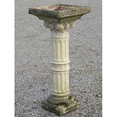 218 - A weathered cast composition stone two sectional bird bath, the square top raised on a fluted cylind... 