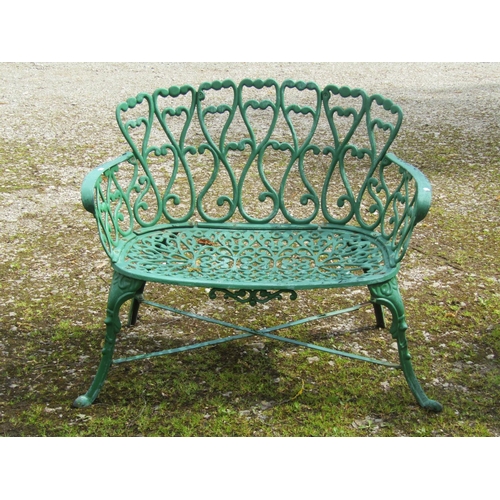 234 - A small decorative green painted cast iron garden bench with repeating pierced open scroll foliate p... 