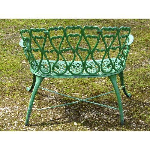 234 - A small decorative green painted cast iron garden bench with repeating pierced open scroll foliate p... 