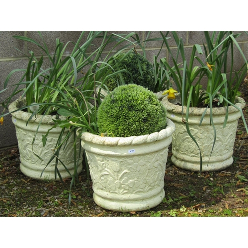 242 - A set of four painted and weathered cast composition stone circular tapered planters with floral rel... 