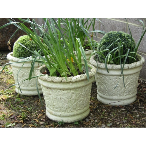 242 - A set of four painted and weathered cast composition stone circular tapered planters with floral rel... 