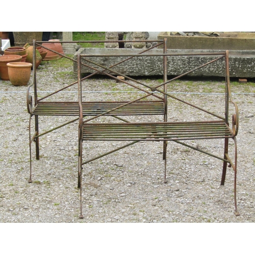 92 - A pair of weathered light steel regency style two seat garden benches with open scrolled arms, open ... 