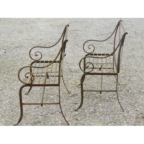 92 - A pair of weathered light steel regency style two seat garden benches with open scrolled arms, open ... 