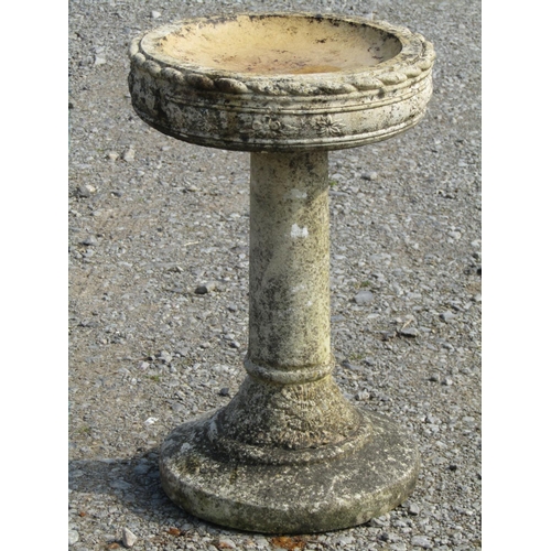 97 - A weathered cast composition stone two sectional bird bath of circular form with repeating rope twis... 