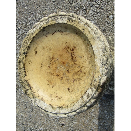 97 - A weathered cast composition stone two sectional bird bath of circular form with repeating rope twis... 