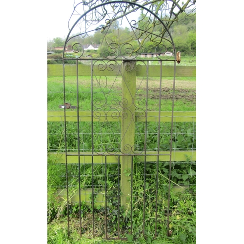 137 - An ironwork arched pedestrian side gate with decorative open scroll detail, 85 cm (full width) x 182... 