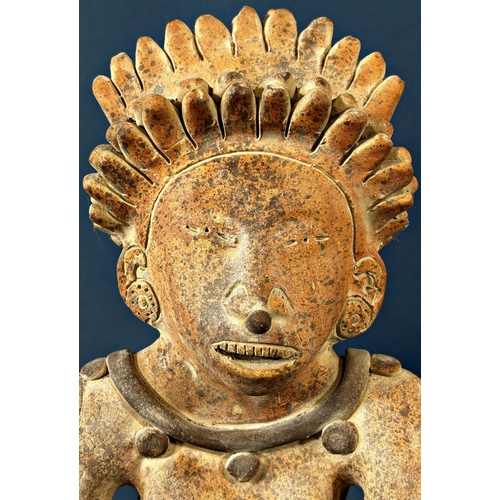 2052 - A South American pottery figure of a seated cross legged character with feathered headdress