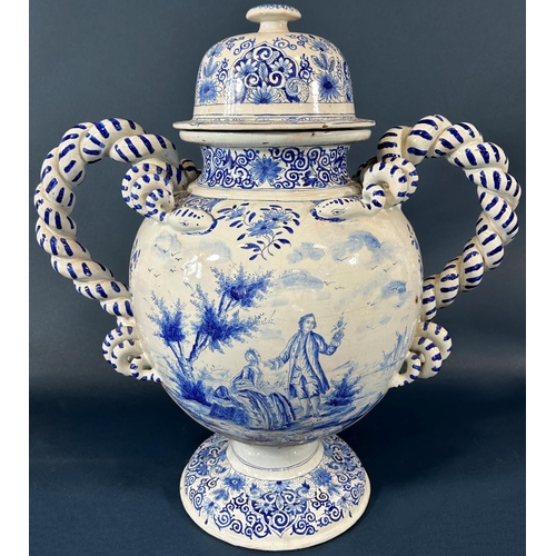 2063 - A substantial continental tin glazed urn and cover in a blue and white colourway with hand painted s... 