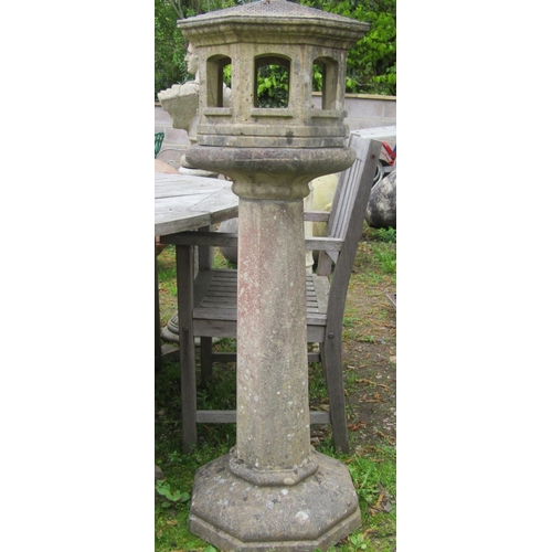 199 - A weathered cast composition stone two sectional bird table of octagonal form with simulated tiled r... 