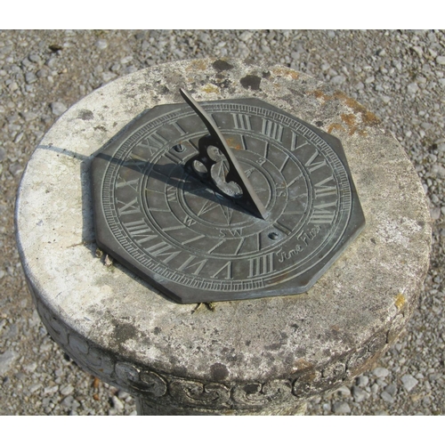 178 - A weathered octagonal sun dial with pierced gnomon set on a composition stone pedestal with relief d... 