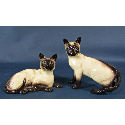 2099 - A collection of ceramic cats to include Beswick Siamese casts in various poses, a grey Winstanley ca... 