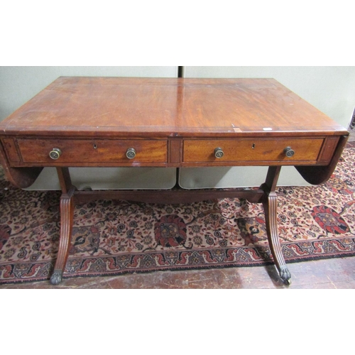 3594 - A regency mahogany sofa table of usual form enclosing two frieze drawers, raised on a stretcher base... 