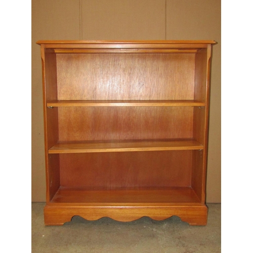 3104 - A reproduction yew wood veneered freestanding open bookcase with two adjustable shelves, 95cm wide x... 