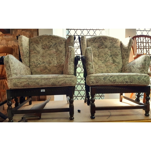 3087 - A pair of colonial style wing chairs with turned spindle work frames and upholstered finish