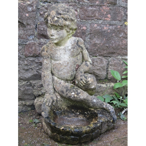 687 - A weathered cast composition stone bird bath with seated boy/cherub surmount, 60 cm high, together w... 